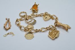 A 9ct gold charm bracelet with various charms including a purse, 'i love you' , rings, etc , 28g
