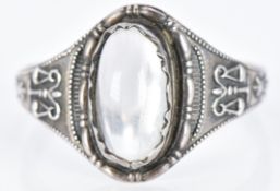 A silver ring set with a moonstone and scale symbols to the shoulders, 1.9g, size N