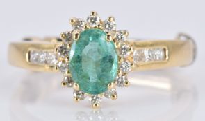An 18k gold ring set with an oval emerald and diamonds, 3.6g, size K