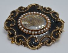 Victorian mourning brooch with a glass compartment to the centre set with hair within a border of