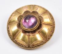 Victorian Etruscan Revival brooch set with a foiled garnet cabochon, verso glass compartment, 9.