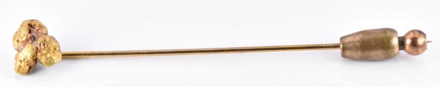 A stick pin set with three yellow metal nuggets, 3g