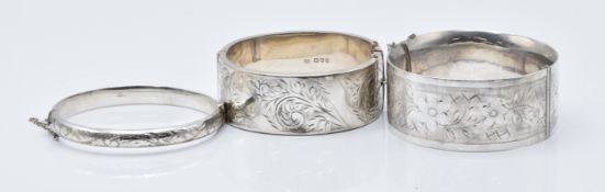 Three hallmarked silver bangles, all with engraved floral decoration, 89g