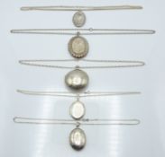 Five silver lockets with engraved decoration and chains, 118g