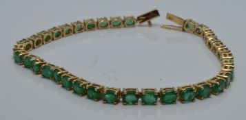 A 9ct gold tennis bracelet set with oval emeralds