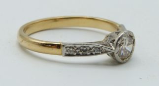 An 18ct gold ring set with a round cut diamond of approximately 0.6ct and with diamond encrusted