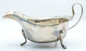 George V hallmarked silver sauce boat with shaped edge, raised on three pad feet, Sheffield 1934