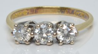 An 18ct gold ring set with three round cut diamonds of approximately 0.25ct, 0.2ct and 0.2ct, 2.