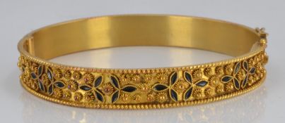 An 18ct gold bangle with blue enamel and raised sphere decoration, 21.7g