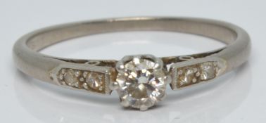 A platinum ring set with a diamond of approximately 0.2ct with further diamonds to the shoulders,