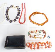 A pressed amber necklace, a coral necklace set with graduated round beads, two beaded agate