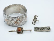 A silver bangle with engraved and rose gold applied decoration, two brooches and a marcasite ring