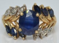 A 10k gold ring set with an oval sapphire, marquise cut sapphires and diamonds, 4.8g, size Q