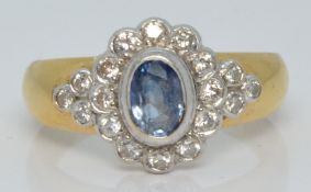 An 18ct gold ring set with an oval cut sapphire surrounded by diamonds, 5.0g, size N/O