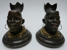 Pair of Goldscheider Wien bronze and gilt metal African head inkwells with hinged lids, on