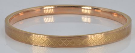Art Deco 9ct gold engine turned flapper bangle, 9.9g