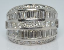 A 14k white gold ring set with round, princess and baguette cut diamonds, total diamond weight