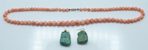 A beaded coral necklace and a pair of turquoise earrings