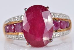 A 9ct gold ring set with a large oval ruby and diamonds, with three round cut rubies to each