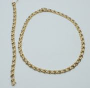 A 14ct bi-coloured gold necklace and bracelet made up of foliate links, 34g