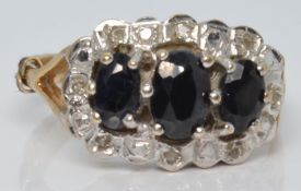 A 9ct gold ring set with three oval cut sapphires surrounded by diamonds, 2.8g, size N