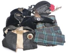 A collection of Scottish dress including several kilts, waistcoats, hats with Scottish badges etc,