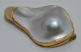 A 9ct gold brooch set with a large abstract pearl, 3 x 4.7cm