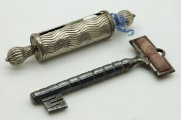 A 19thC steel needle case in the form of a key with agate finial and a tape measure, longest 9cm