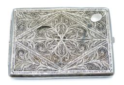 White metal filigree cigarette case with scrolling design, no visible silver marks, width 10.5cm,