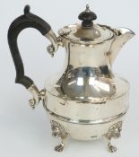 George V hallmarked silver teapot raised on pad feet with lion mask decoration, London 1928, maker