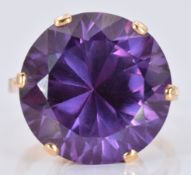 A yellow metal ring set with a large round cut synthetic sapphire, 15.7g, size U