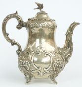 Victorian hallmarked silver teapot with bulbous body and embossed decoration, raised on four feet