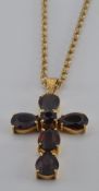 A 18ct gold pendant in the form of a cross set with garnets (5.6g) on a 9ct gold rope twist necklace