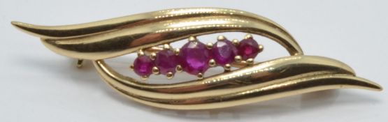 A 9ct gold brooch set with five rubies, 1 x 4cm, 3.3g