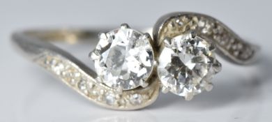 An early 20thC platinum ring set with two diamonds, each approximately 0.4ct, with diamond encrusted