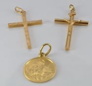 An 18ct gold cross, an 18ct gold St Christopher (4.8g) and a yellow metal crucifix (1.6g)