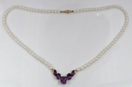A cultured pearl necklace with a 10k gold section set with amethysts