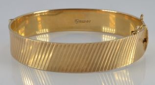 A 9ct gold bangle with retro ridged decoration, London 1967, 28.0g
