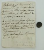 Small bronze Roman coin with old disclaimer describing the area where the coin was picked up in