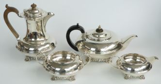 George V hallmarked silver four piece tea set raised on scrolling feet with Leitch family crest,
