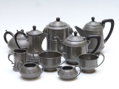 A collection of pewter teaware including some with hammered Arts and Crafts style decoration, height