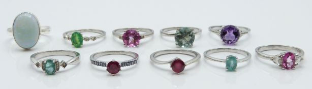 Ten silver rings set with ruby, blue opal, pink topaz, green fluorite, ruby, emerald, amethyst, opal