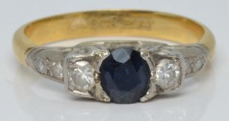An 18ct gold ring set with a round cut sapphire and six diamonds in a platinum setting, 3.7g, size O