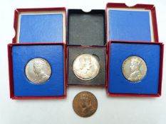 Two cased silver George V commemorative medallion coins, a bronze example and a Elizabeth II