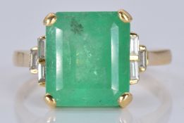 An 18ct gold ring set with a natural emerald cut emerald of approximately 5.97ct and three