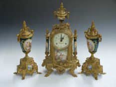A brass clock garniture with decorated porcelain panels, a 20thC reproduction of an 18thC design,