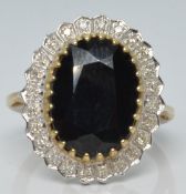 A 9ct gold ring set with a large oval sapphire surrounded by diamonds, 5.1g, size M/N