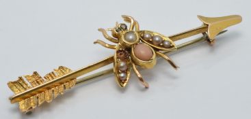 Edwardian yellow metal brooch in the form of a fly and arrow, set with coral and seed pearls and