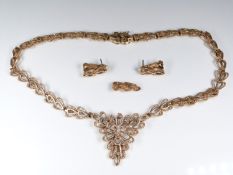 A 9ct gold necklace and earrings in a stylised floral design set with a diamond, 58g