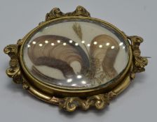 Victorian mourning brooch within a scrolling border set with hair, 5 x 4.2cm